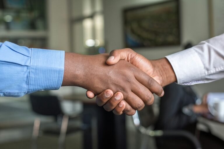 Two financial professionals shaking hands representing standard retirement financial planning